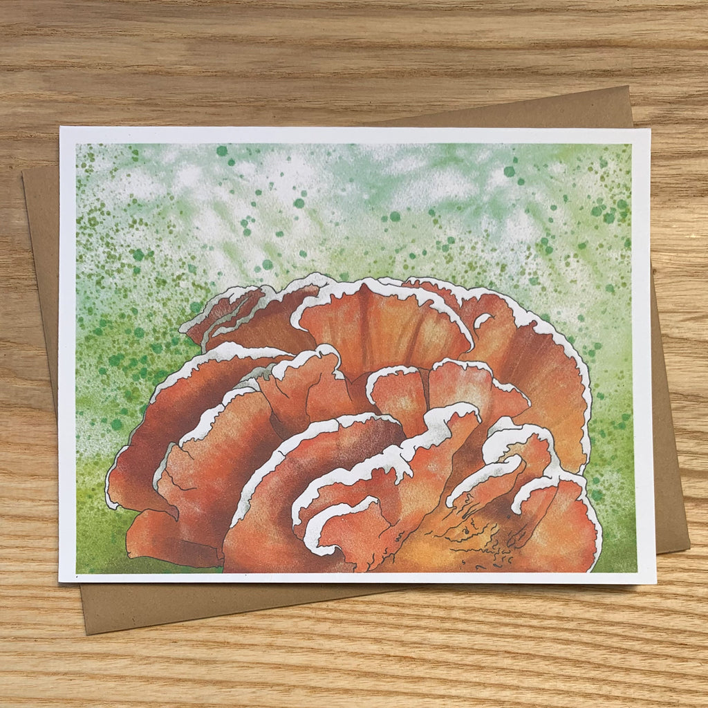 Greeting card featuring illustration of an orange chicken-of-the-woods mushroom with white tips on a green background