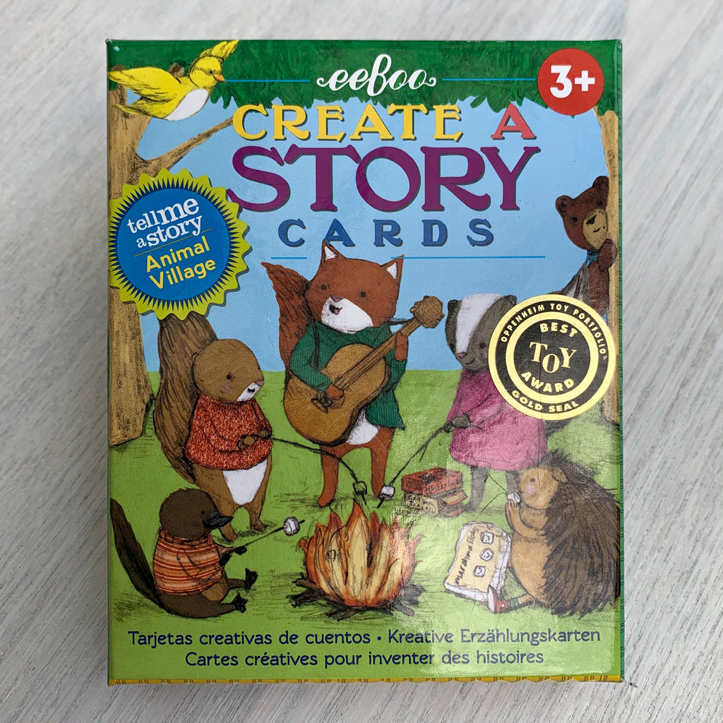 Card game box cover with illustration of woodland animals toasting marshmallows and singing around a campfire