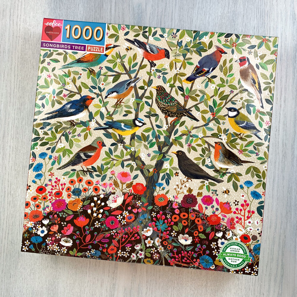 Front cover of Songbirds Tree puzzle box featuring many pretty illustrated birds in one small tree surrounded by leaves and flowers.