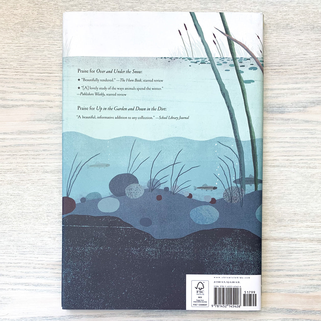Back cover of Over And Under The Pond featuring a placid, blue illustration of a pond with lily pads and cattails at its surface and fish and marine vegetation below.