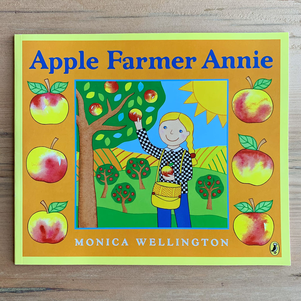 Paperback picture book cover with illustration of pale-skinned, yellow-haired lady farmer collecting apples from a tree