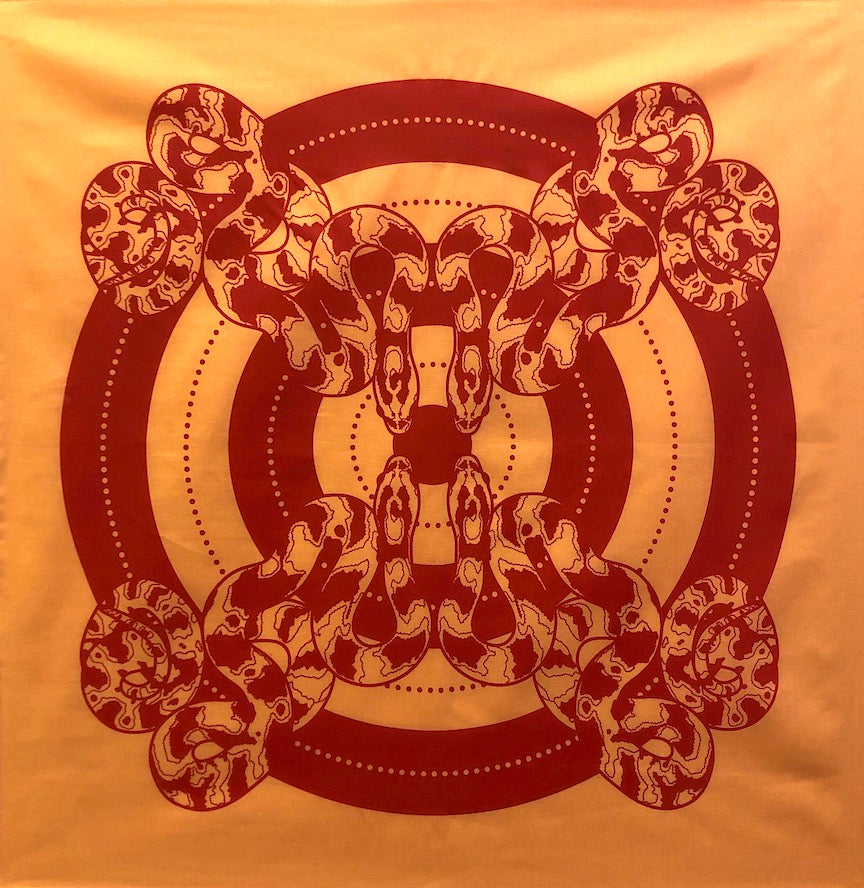 Orange bandana with a deep orange print of four snakes facing one another against a bullseye background.