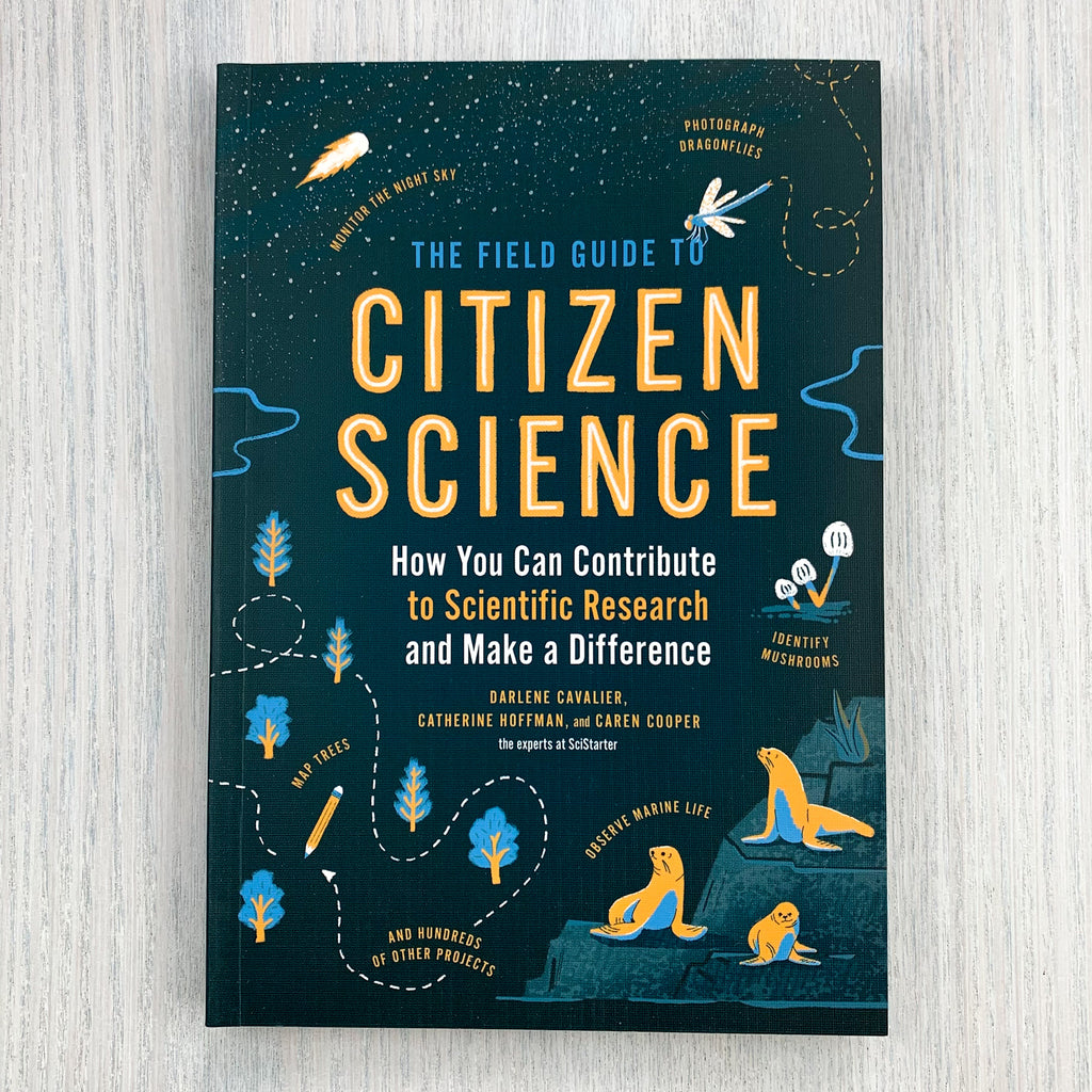 Front soft cover of The Field Guide to Citizen Science with bold orange and blue text on a dark, starry background.  Featuring illustrations of sealions, mushrooms, trees, bugs, and a comet streaking through the sky.