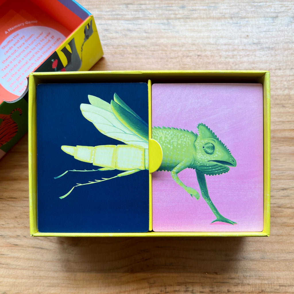 inside of box divided into two compartments for cards. One top card is the back of a firefly and the other is the front of a chameleon.