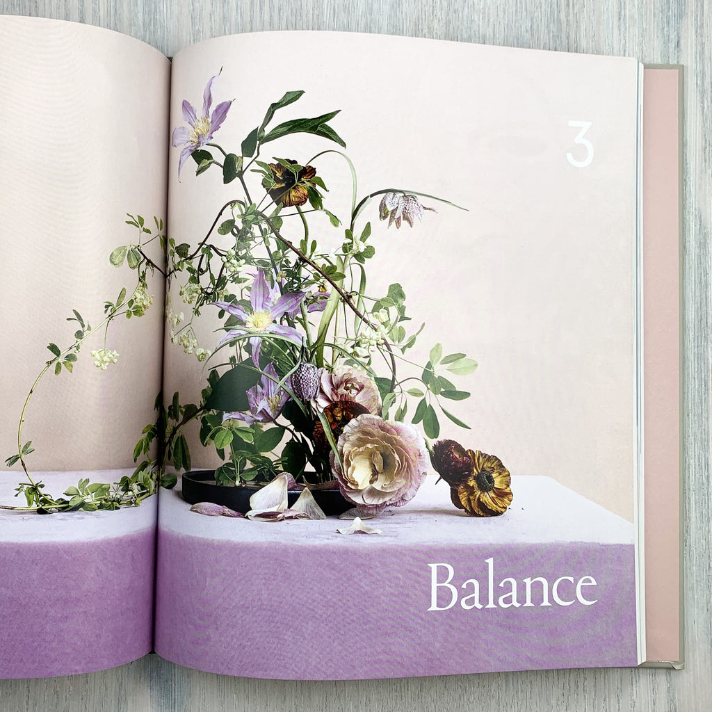 Two-page spread with trailing purple floral arrangement and the text "Balance"