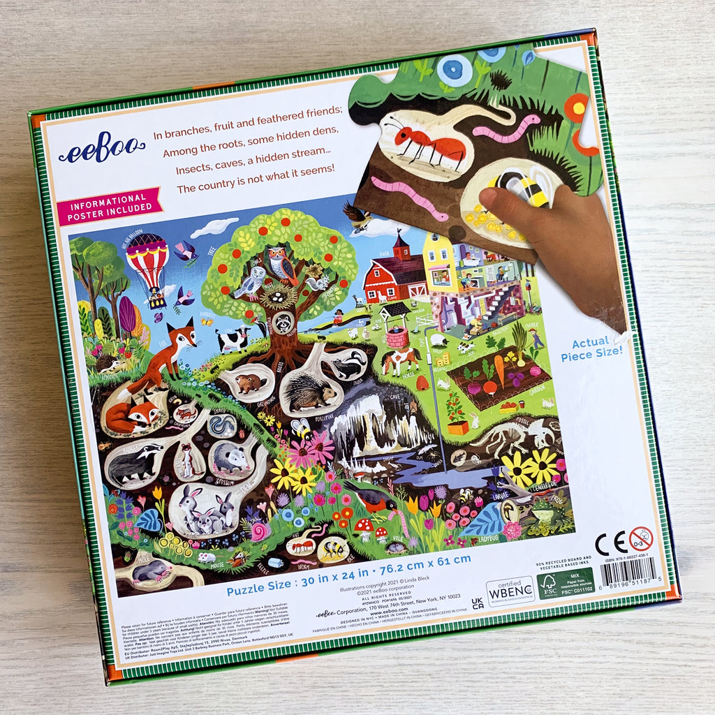 Back box cover of Within the Country Puzzle showing completed puzzle and oversized puzzle piece next to a child's hand.