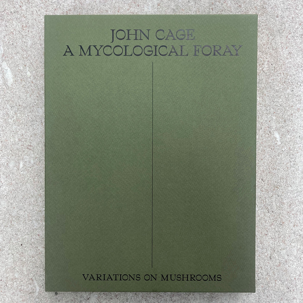 Front cover of paper case for JOHN CAGE: A MYCOLOGICAL FORAY displaying simple bold text of the title and "VARIATIONS ON MUSHROOMS" on a plain green paper background with a pleasant texture.