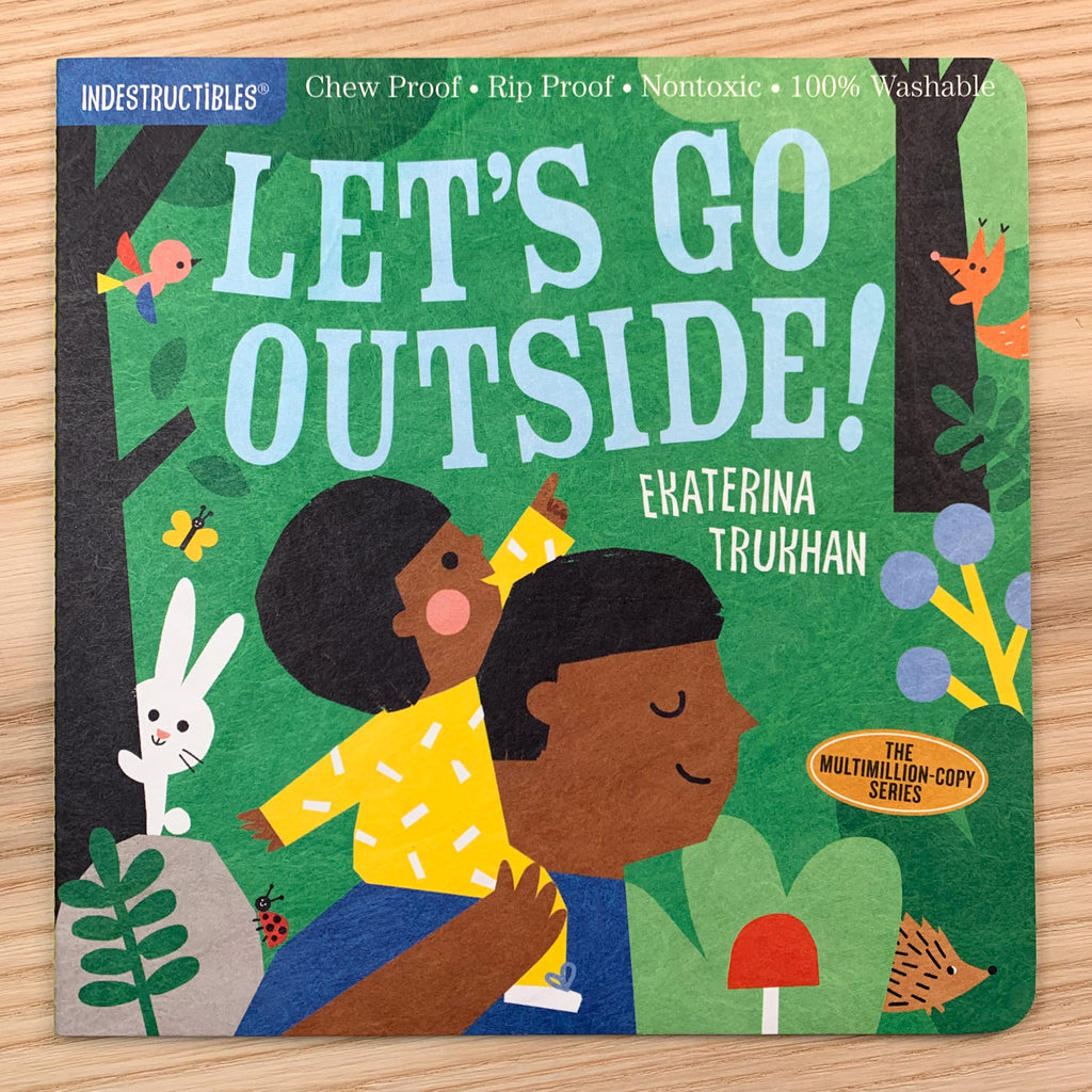Durable front cover of Let's Go Outside! featuring a delighted child on their parent's shoulders surrounded by forest critters during a nice walk through the woods.
