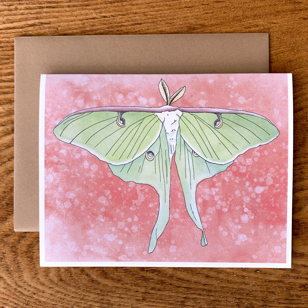 Greeting card featuring a stylized green watercolor moth on a red background.  Shown with brown paper envelope.