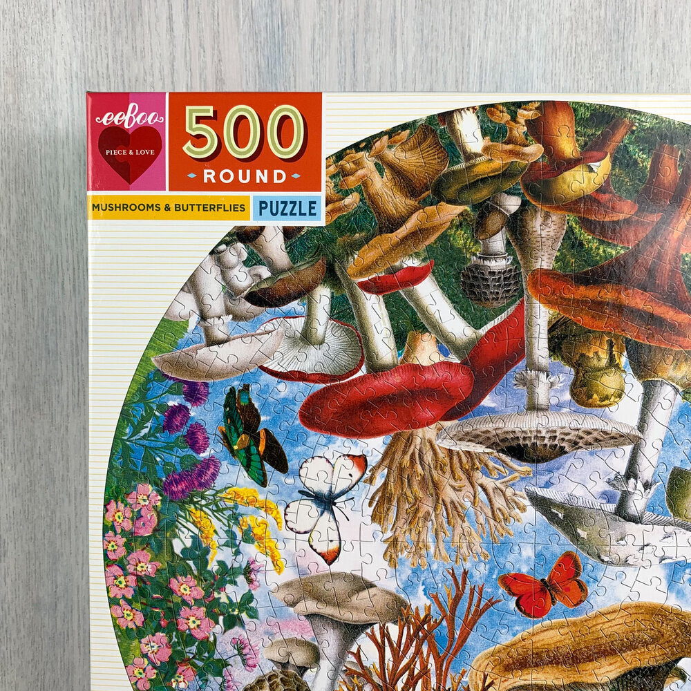 Top left corner of jigsaw puzzle box with a close up of the circular puzzle and its mushroom and butterfly species.