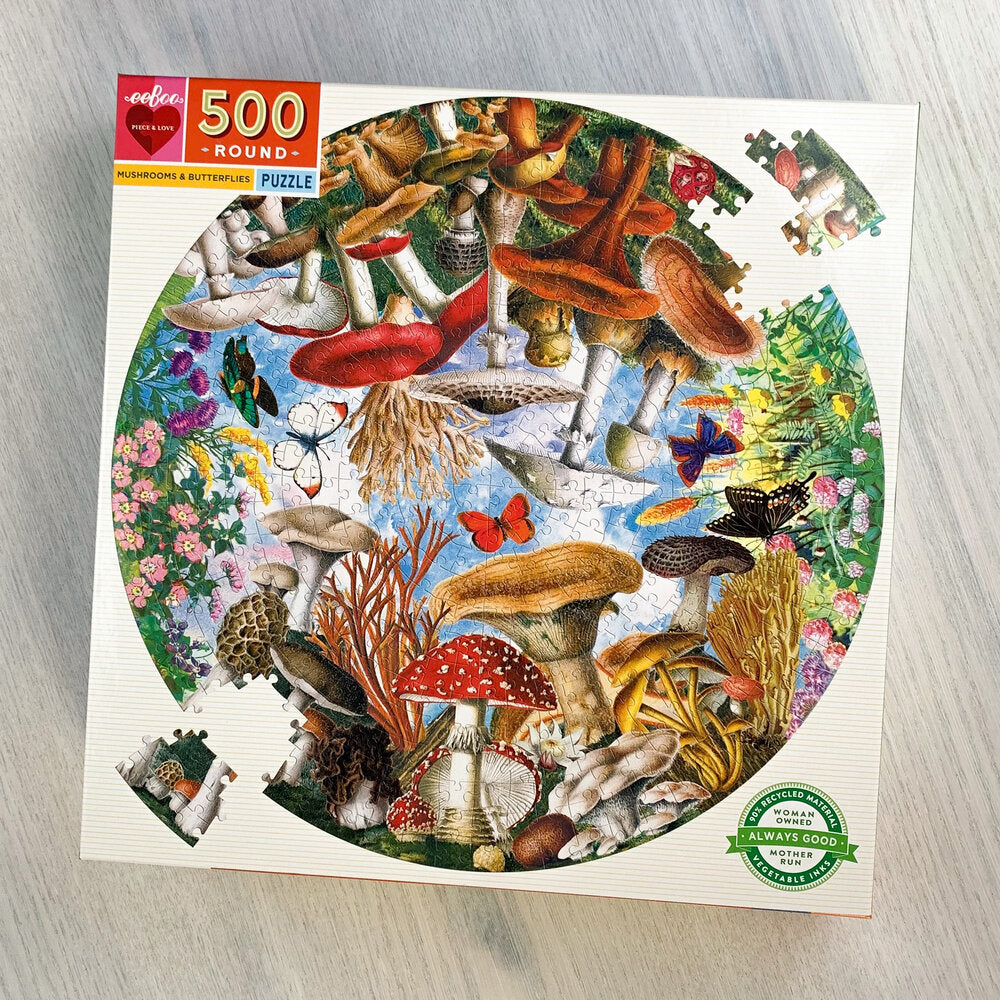 Colorful front box cover showing an almost completed circular jigsaw puzzle with curved puzzle pieces.  Many mushroom and butterfly species are represented in illustration.