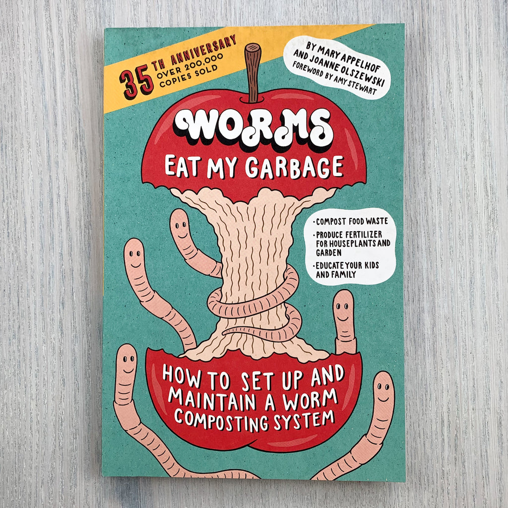 Front cover of Worms Eat My Garbage featuring a goofy illustration of worms smiling around a red apple core.